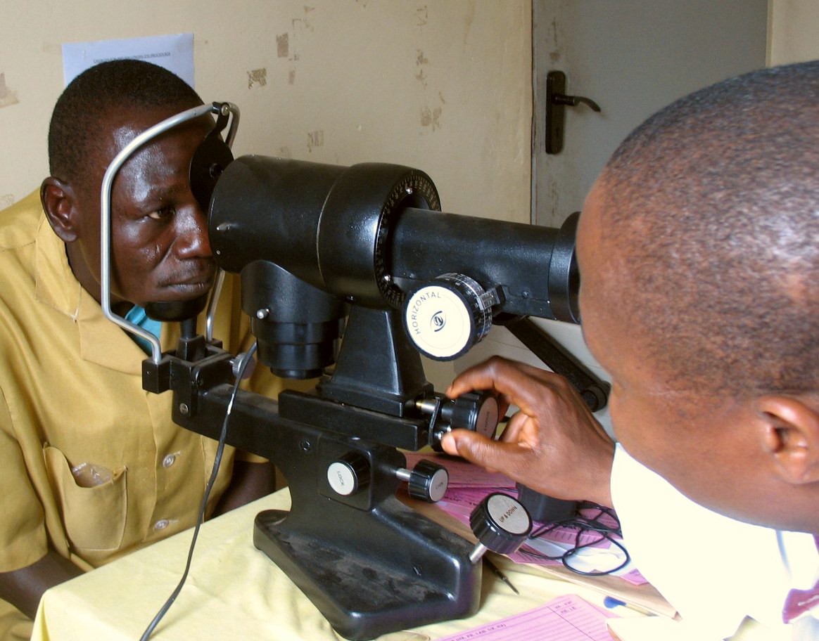 Eye doctor measuring a patient's corneal curvature with a manual keratometer