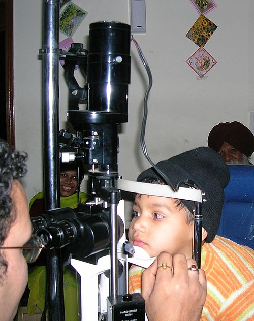 Child undergoing slit-lamp examination by an ophthalmologist