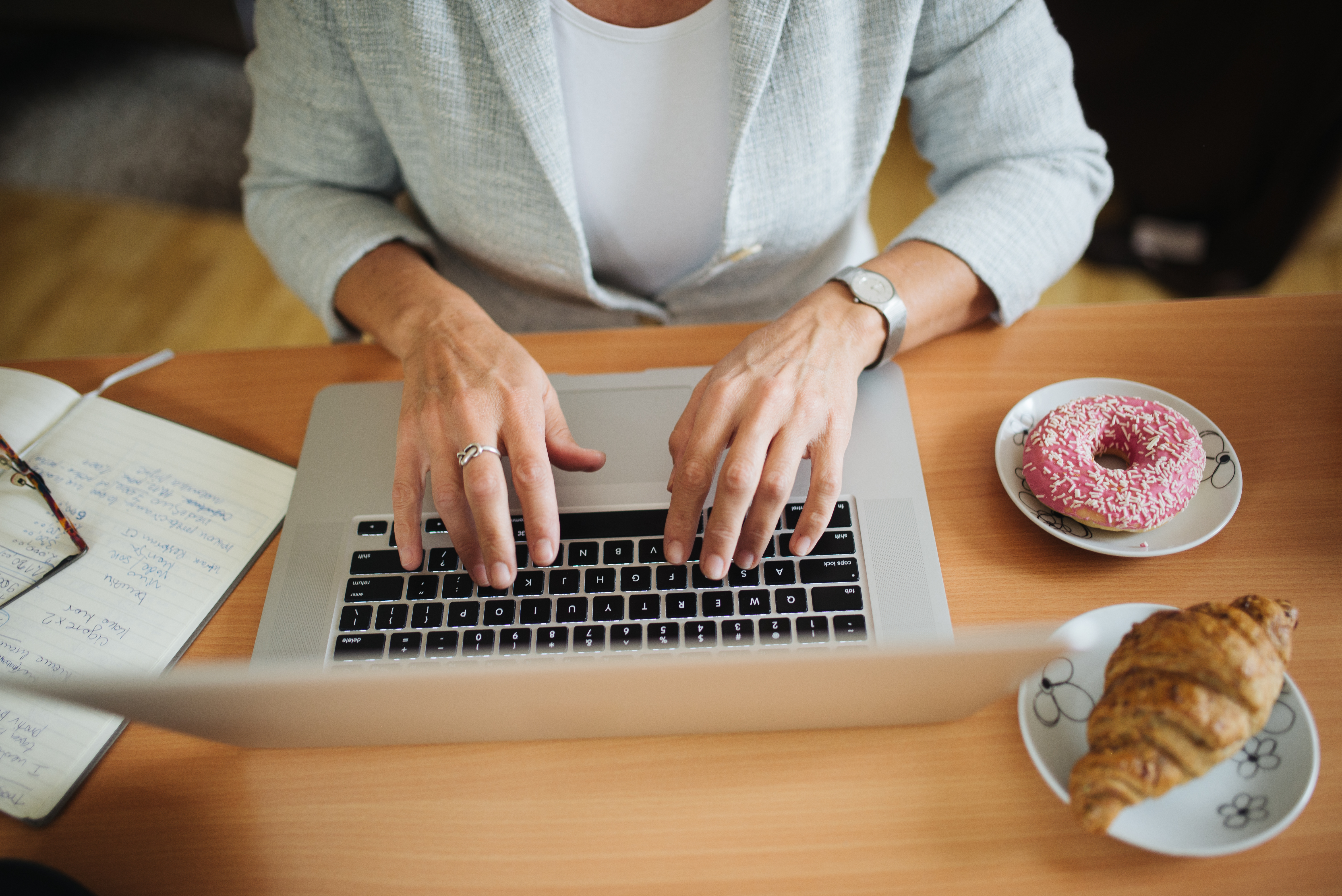 Person using a laptop at a table, representing prolonged screen use