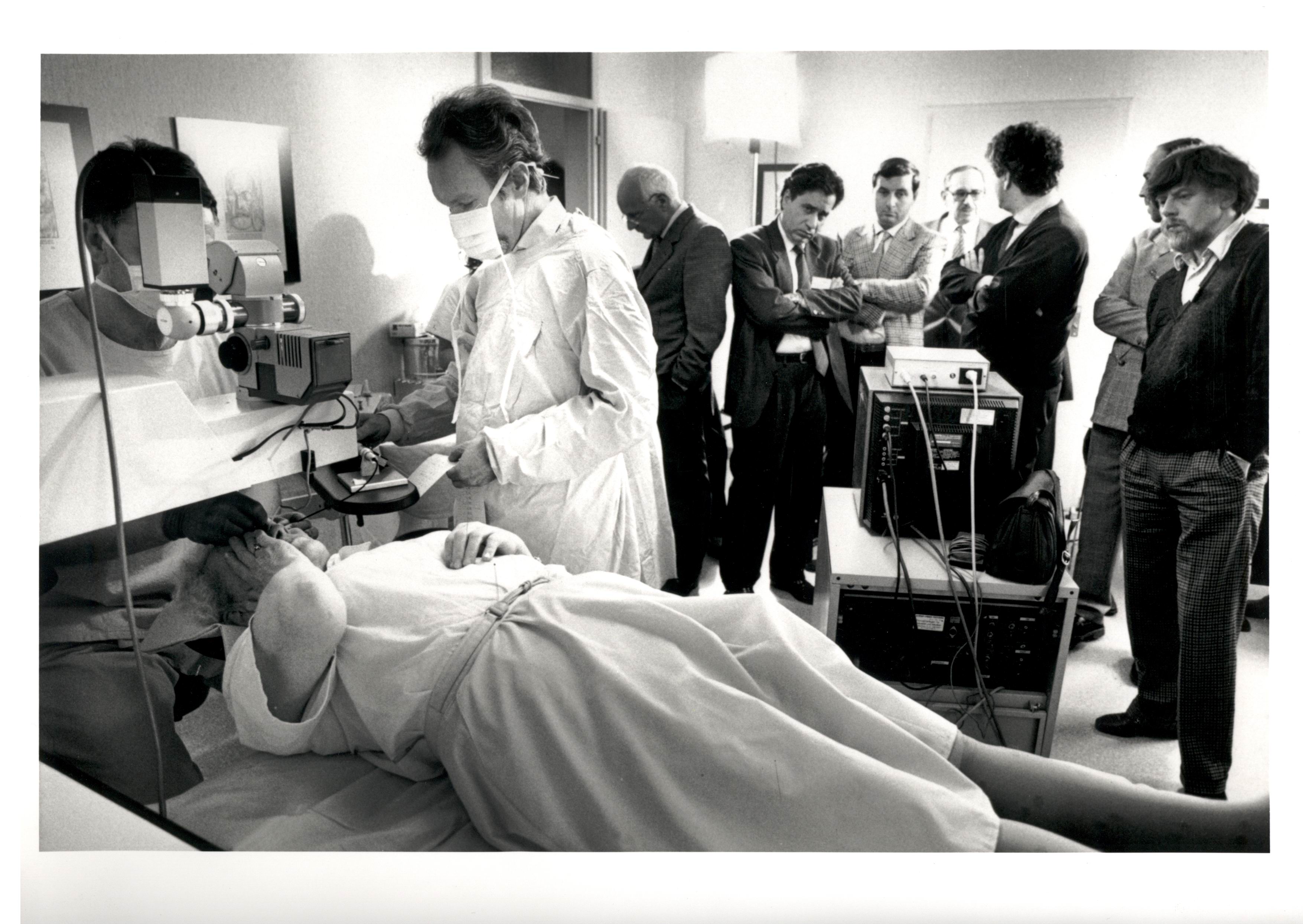 Historic black-and-white photo of surgeons performing early laser vision-correction surgery.