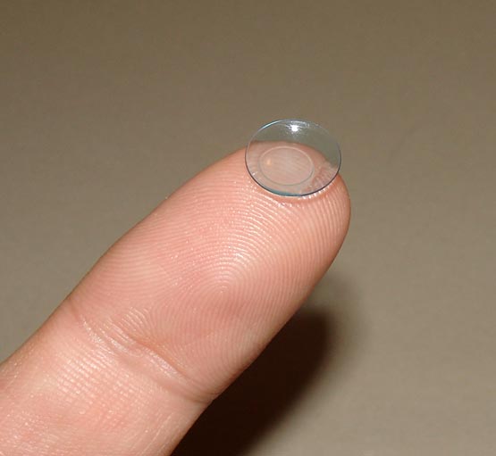 Rigid gas-permeable contact lens balanced on a fingertip.