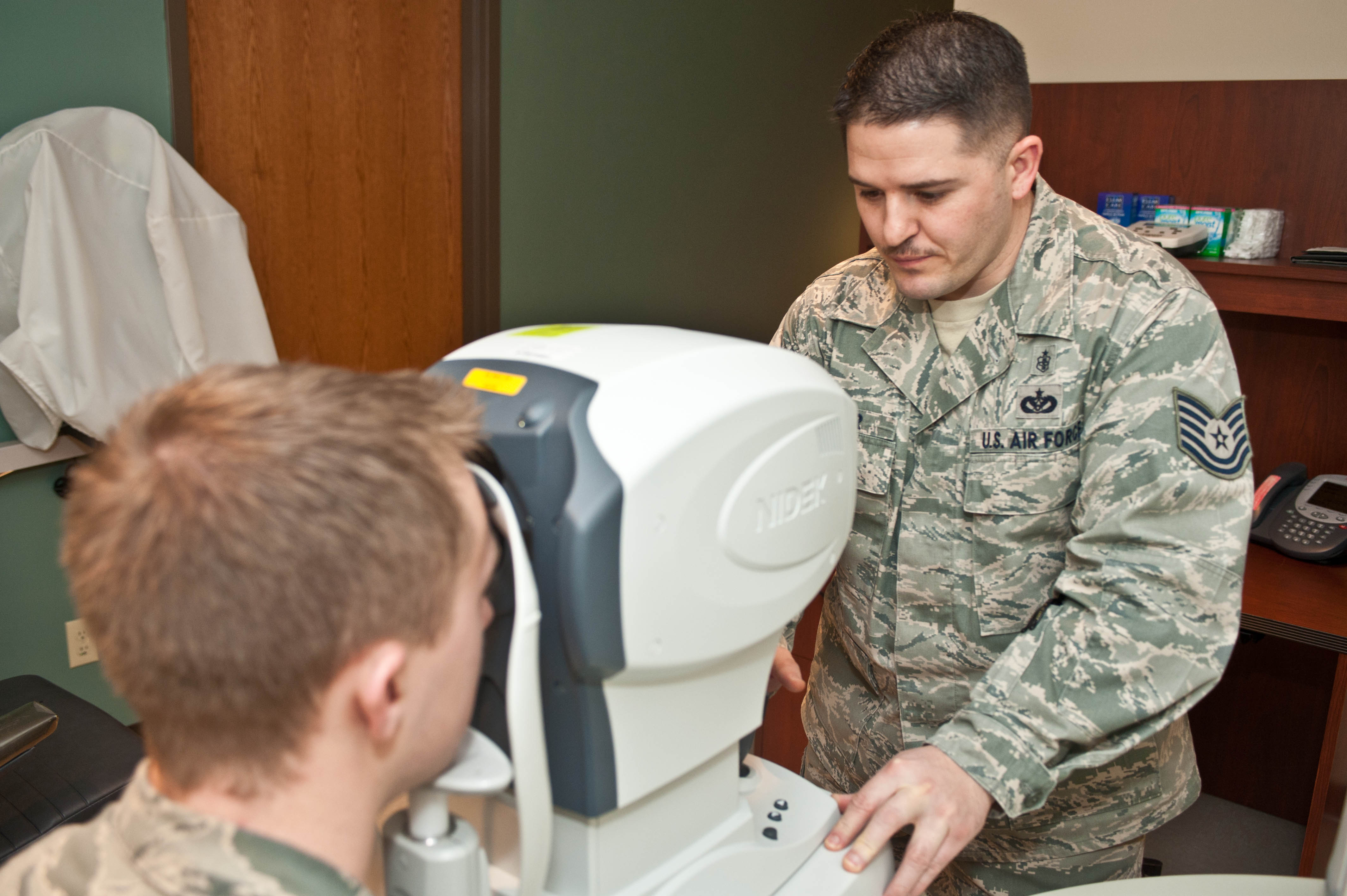 Technician using an autorefractor during an eye exam