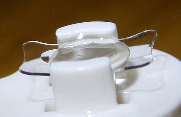 Foldable acrylic intraocular lens in a holder